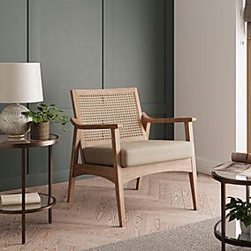 a living room filled with furniture and a lamp on top of a wooden table next to a window