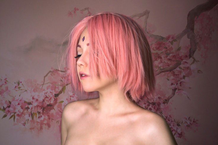 a woman with pink hair is posing for the camera