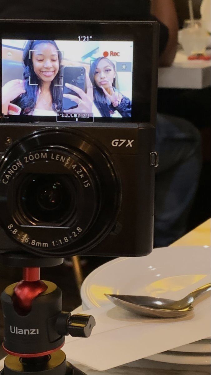 a camera is sitting on top of a table with plates and silverware in front of it