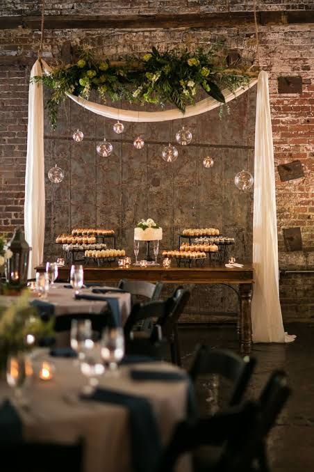 a table with cupcakes on it in front of a brick wall