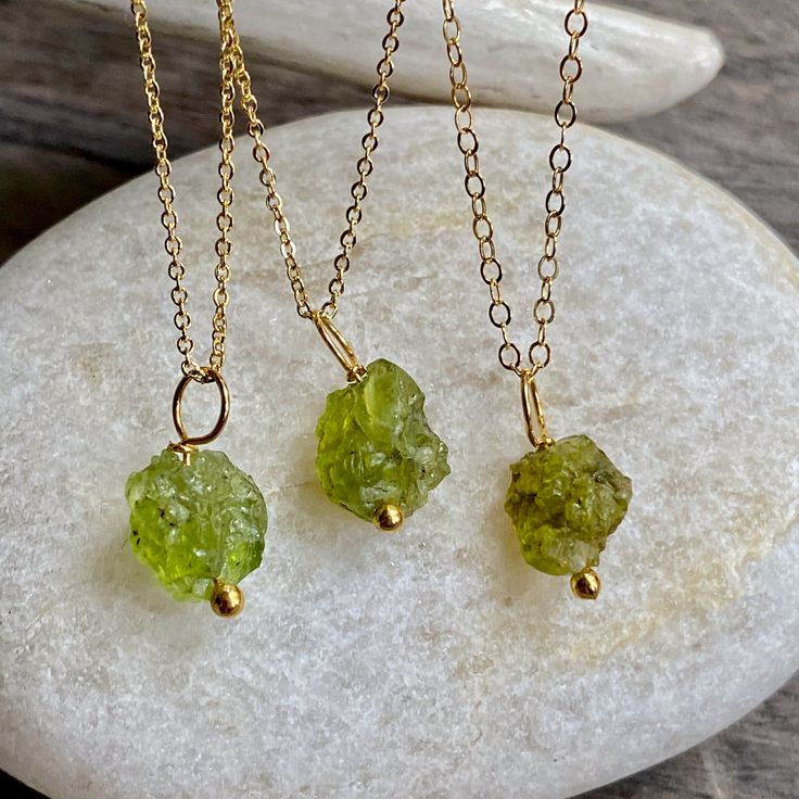 Beautiful and all-natural peridot gemstones hung from a dainty an light-catching gold fill chain. Peridot symbolizes strength. It was once believed that the green peridot crystals found in volcanic ashes were the tears of the volcano goddess, Pele. When set in gold, this gem was said to protect the wearer from nightmares. Peridots are the birthstone for August and also traditionally given on the 16th wedding anniversary. ★Chain- High quality 14k gold fill in your choice of length ★Stone-Untreate Green Peridot Necklace For May Birthstone, Lime Green Peridot Necklace For May Birthstone, Green Peridot Gemstone Necklace, Green Peridot Pendant Necklace, Lime Green Peridot Jewelry For May Birthstone, Green Peridot Necklace For Gift, Lime Green Necklace For May Birthstone Gift, Lime Green Necklace Gift For May Birthstone, Peridot Gemstone Pendant Necklace