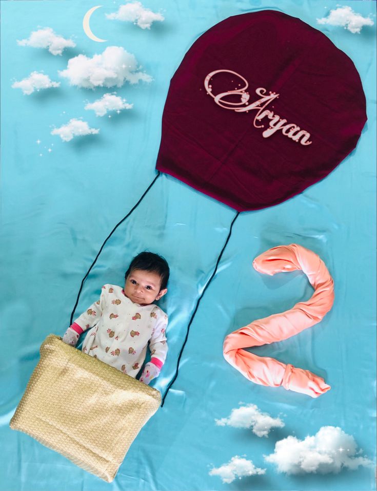 a baby is sitting in the air with a hot air balloon above him and an orange flamingo