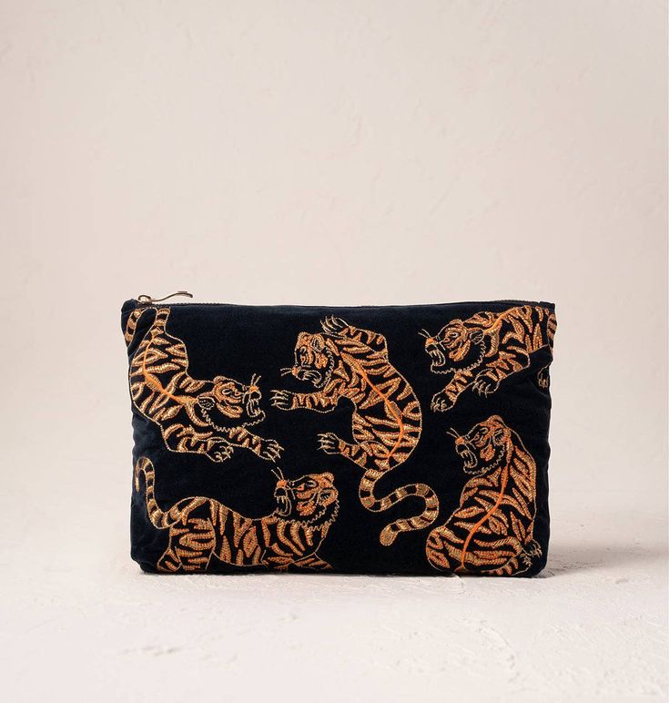 This design showcases vibrant embroidery in vivid threads, capturing the bold and untamed beauty of the natural world. Its courageous and striking appearance adds a touch of the wild to everyday use. Designed to make your life a little more organised and a lot more luxurious, this timeless Everyday Pouch features delicate embroidery on soft, durable bases. Ideally sized, it is perfect for storing your daily essentials, fitting in your handbag, or using as a clutch. Material: Velvet Cotton Base Dimensions: 20x30cm Machine washable at 30 degrees Gold zip closure Double sided design 100% cotton lining Travel Beauty Bag, Elizabeth Scarlett, Beauty Bags, Wild Tiger, Tiger Design, Eye Masks, Holiday Essentials, Charcoal Black, Travel Beauty