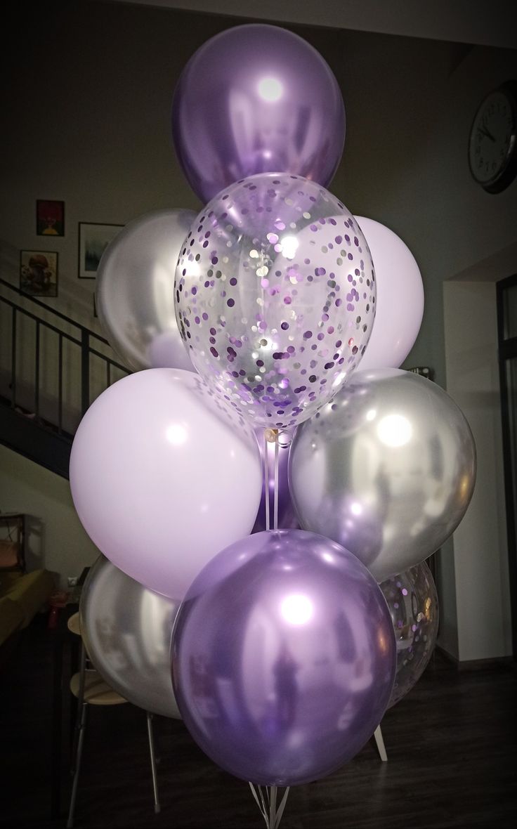 a bunch of balloons that are in the shape of a tower with confetti