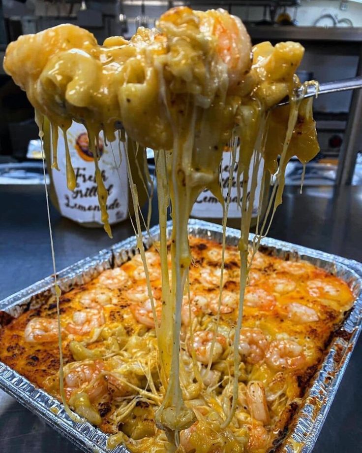 some food is being served on top of a tray with sauce and cheese drizzled over it