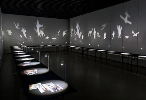 an empty room with many tables and lights on the walls, all lit up by different types of lighting