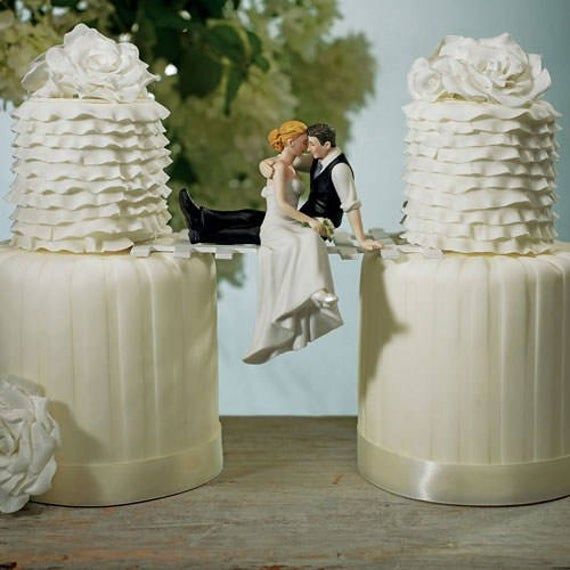 a bride and groom figurines sitting on top of wedding cakes