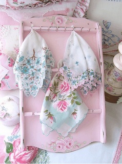 pink and white cloths are laid out on an old fashioned tray, with other items in the background