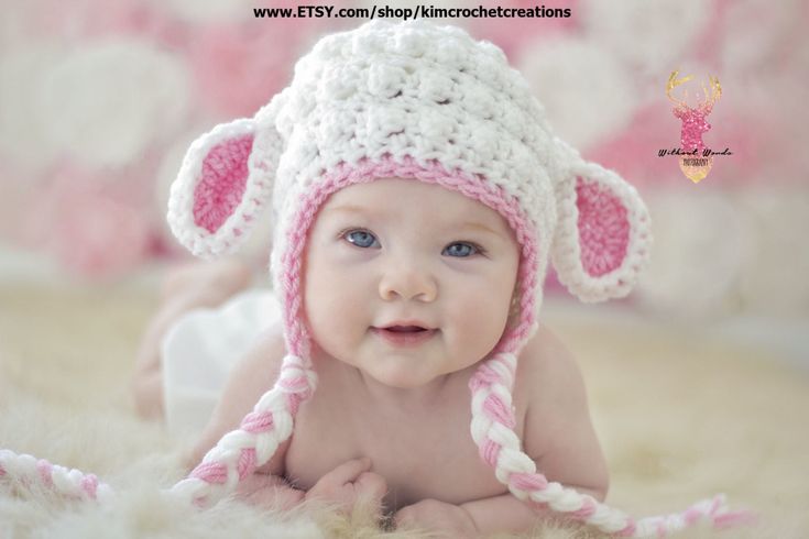 a baby wearing a pink and white crocheted hat