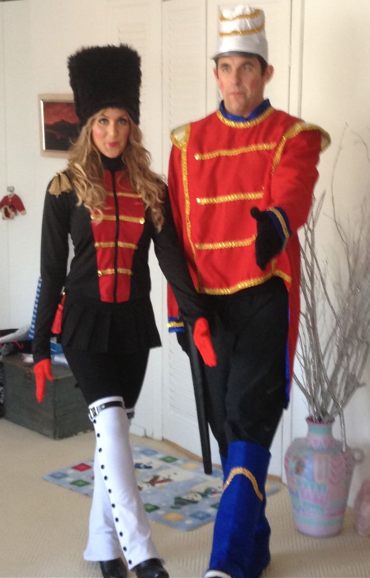 a man and woman in costume walking down a hallway together, both dressed up as soldiers