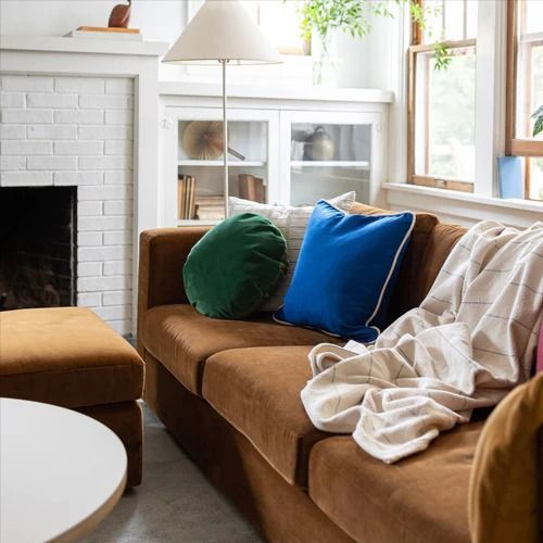 a living room with a couch, chair and fire place in it's center