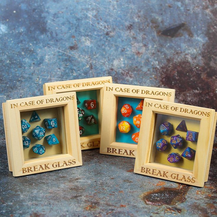 three small wooden boxes with dices in them and the words break glass written on them