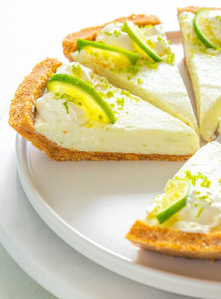 a white plate topped with slices of cheesecake covered in green and yellow toppings