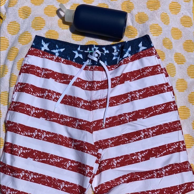 Red, White, And Blue Striped Draw String Waist Comfortable Red Swim Trunks For Spring Vacation, Casual Beach Bottoms With Flag Print, Casual Flag Print Bottoms For Beach, Casual Bottoms With Flag Print For Beach, Casual Beach Shorts With Flag Print, Red Cotton Swim Trunks For Beach, Red Cotton Swim Trunks For The Beach, Casual Shorts For 4th Of July Beach, Casual Beach Bottoms For 4th Of July