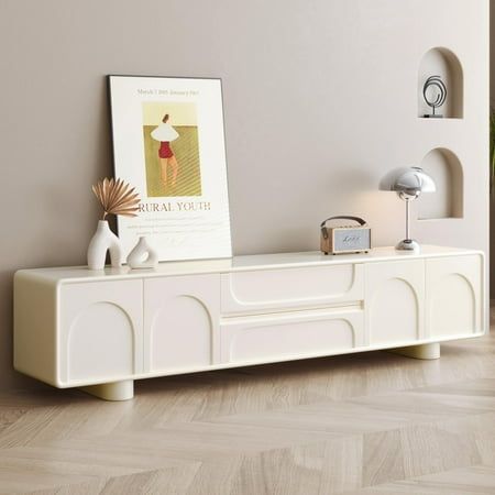 a living room with a large white entertainment center on top of a hard wood floor