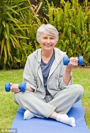 an older woman sitting on a yoga mat with two dumbbells in her hands