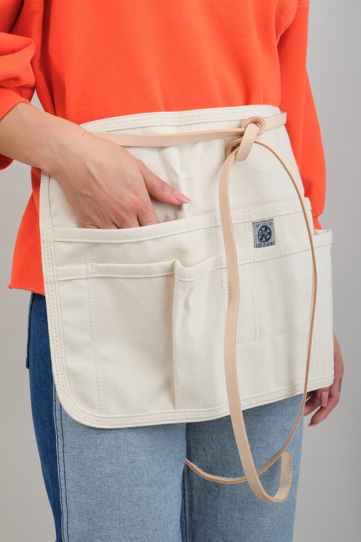 a woman is wearing an apron and has her hands in the pocket as if to hold something