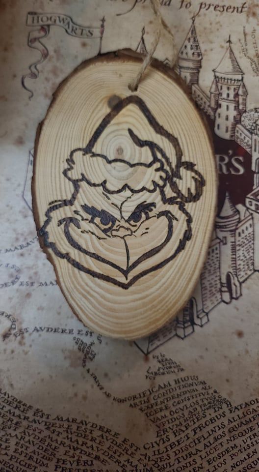 a wooden ornament with a santa claus face on it