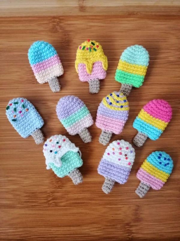 crocheted ice cream lollipops on a wooden surface