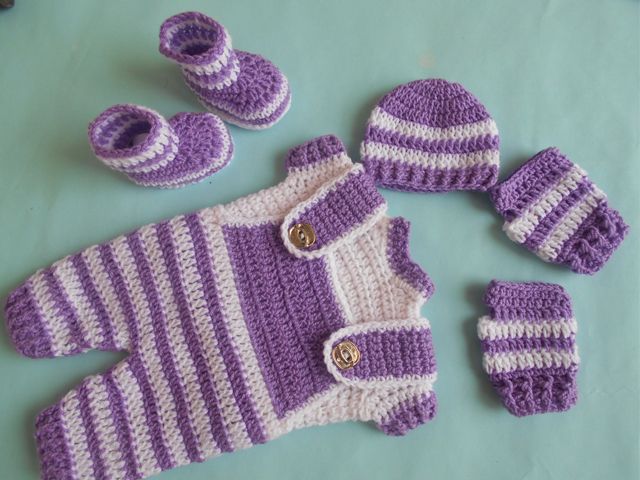 a crocheted baby outfit and booties on a table