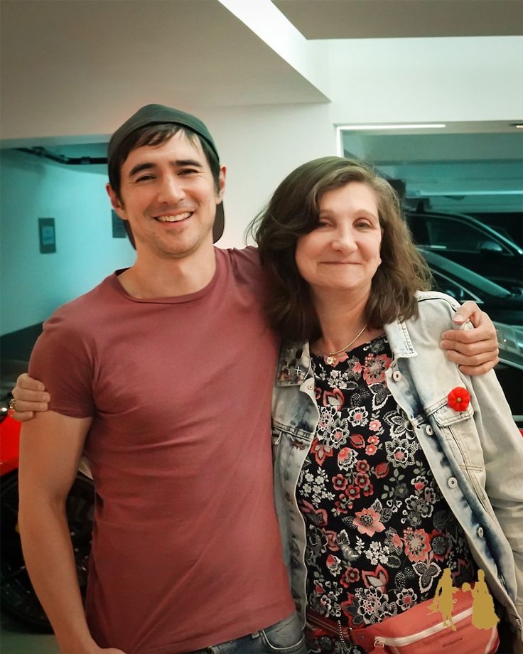 a man standing next to a woman in front of a car