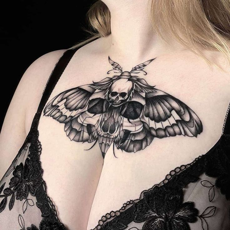 a woman's chest with a moth tattoo on it