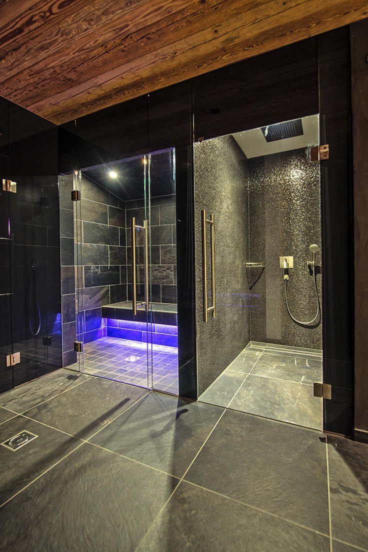 a walk in shower sitting inside of a bathroom next to a tiled floor and walls