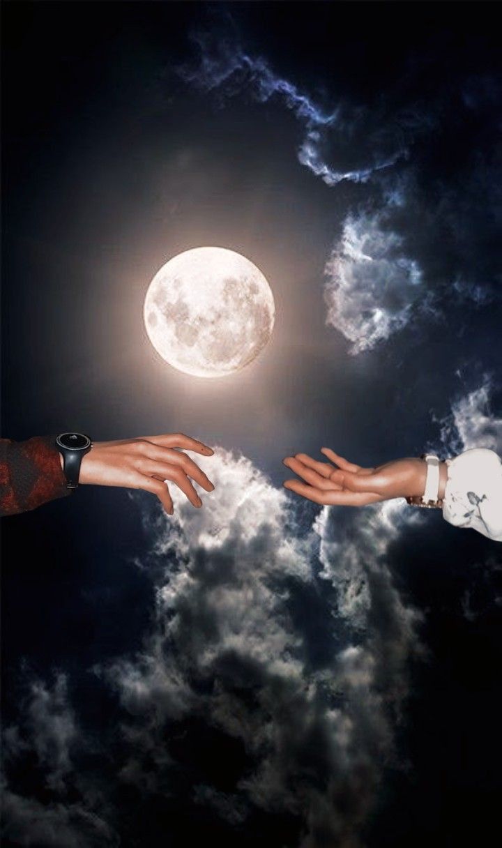 two hands reaching out towards each other in front of a full moon and cloudy sky