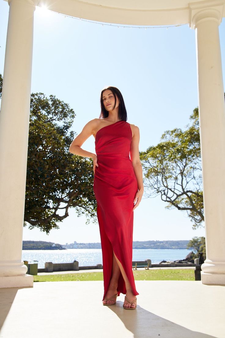 a woman in a red dress posing for the camera with her hands on her hips