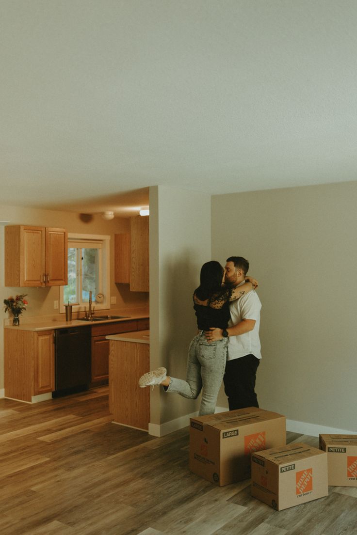 two people standing on boxes in the middle of a room with hardwood floors and walls