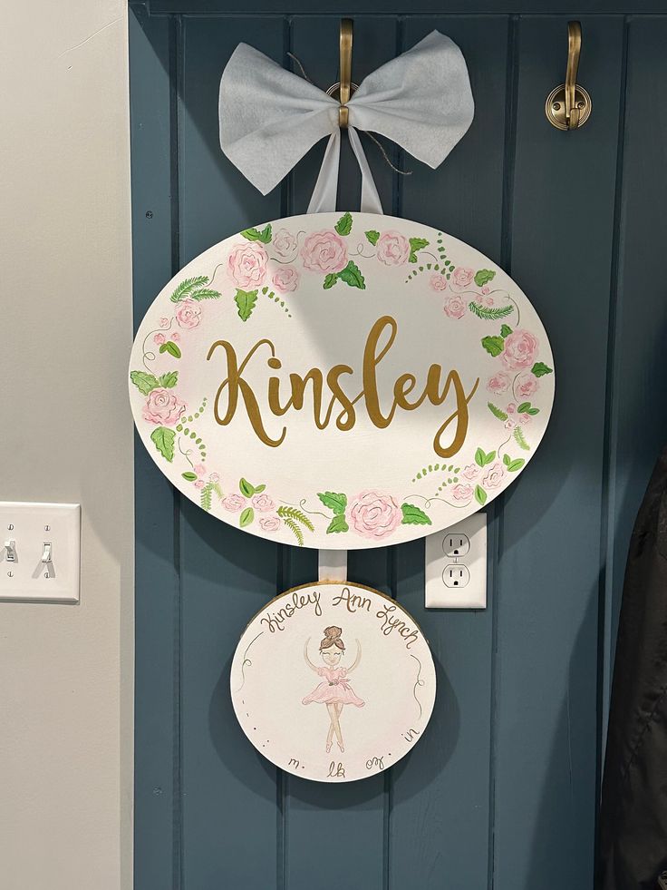 a wooden sign hanging from the side of a blue door next to a coat rack