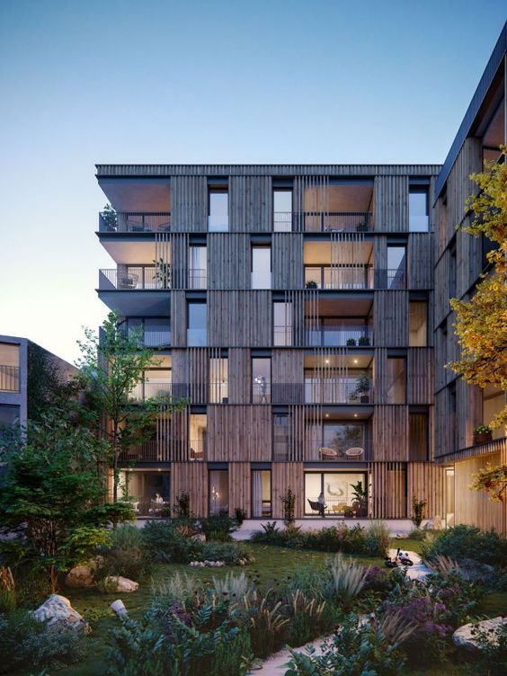 an apartment building with many balconies on the front and second story, surrounded by greenery