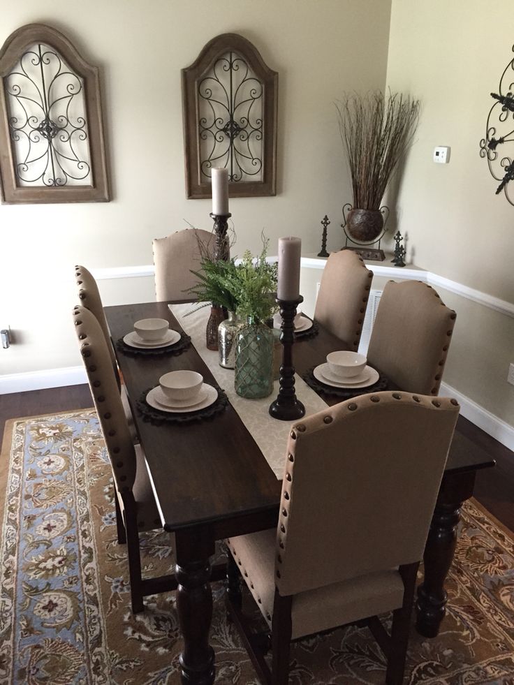 a dinning room table set for six with plates and place settings on the table