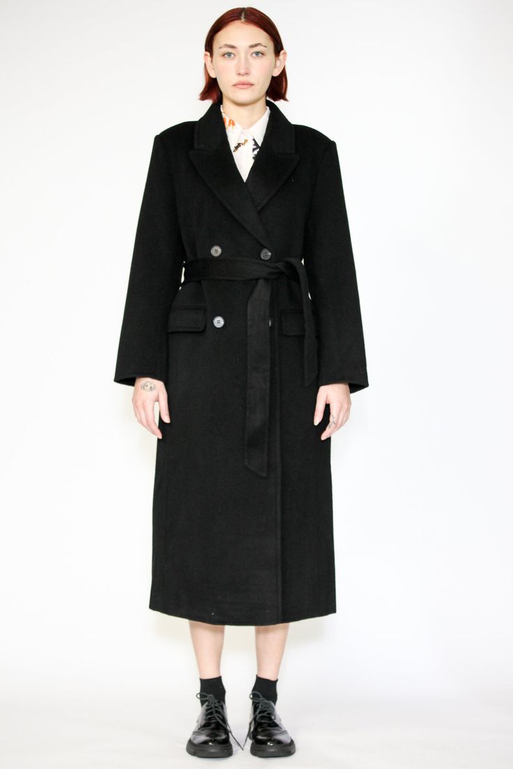 Indulge in timeless elegance with our Double-Sided Wool Black Wrap Coat. This heavyweight classic exudes sophistication and comes complete with a belt for versatile styling. The double-breasted design adds an extra layer of refinement, while the two pockets provide both style and convenience. What sets this coat apart is its full lining, ensuring comfort and warmth in every wear. Wrap yourself in luxurious fashion that effortlessly combines style and practicality. Elevate your winter wardrobe with this standout piece that promises both cozy comfort and chic allure. Composition: 100% Wool Heavyweight fabric Designed for a relaxed fit, fits true to size Made in New York SNOWXUEGAO.COM Elegant Long Coat With Belt Loops, Classic Formal Outerwear With Belt Detail, Luxury Belted Outerwear For Formal Occasions, Elegant Black Outerwear With Self Belt, Luxury Formal Outerwear With Belt, Elegant Notch Lapel Outerwear With Belt, Elegant Black Outerwear With Belted Cuffs, Classic Black Outerwear With Belt Loops, Classic Fitted Outerwear With Belt Detail