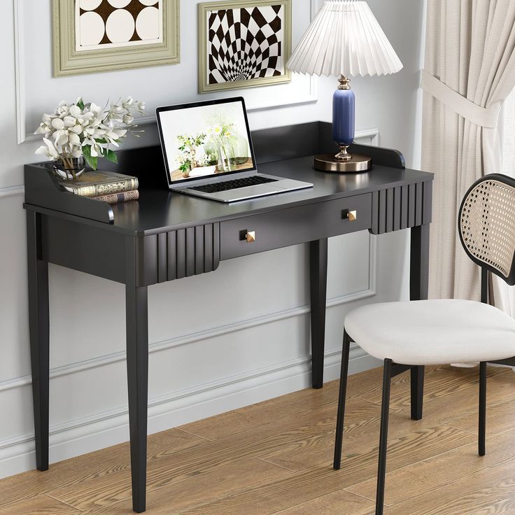 a laptop computer sitting on top of a wooden desk next to a lamp and chair