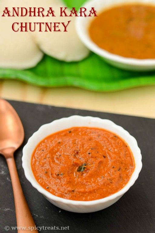 there is a bowl of red sauce on the table next to a spoon and some other food