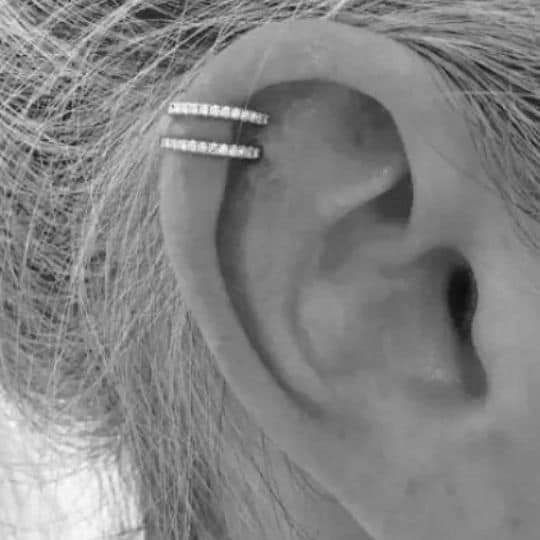 a woman's ear is shown with two thin rings on it