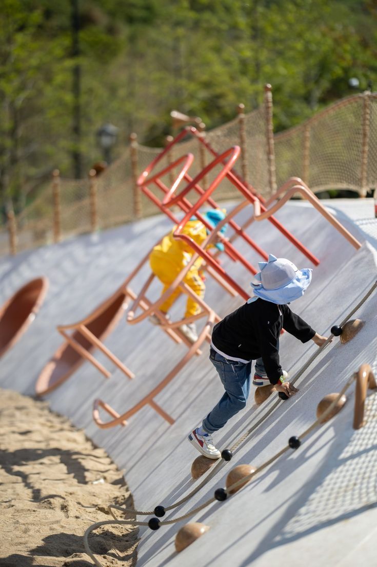 a little boy riding skis down a slide