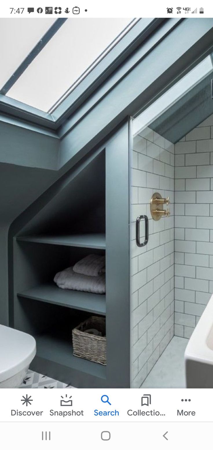 a white toilet sitting next to a bath tub under a skylight in a bathroom