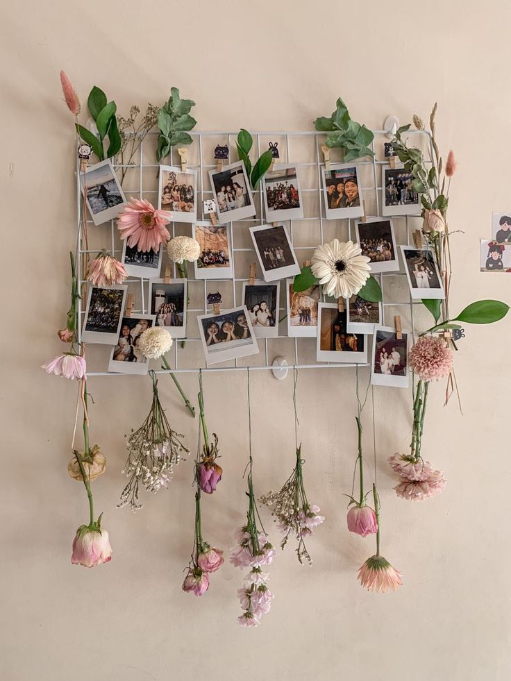 flowers are hanging on the wall with pictures attached to them