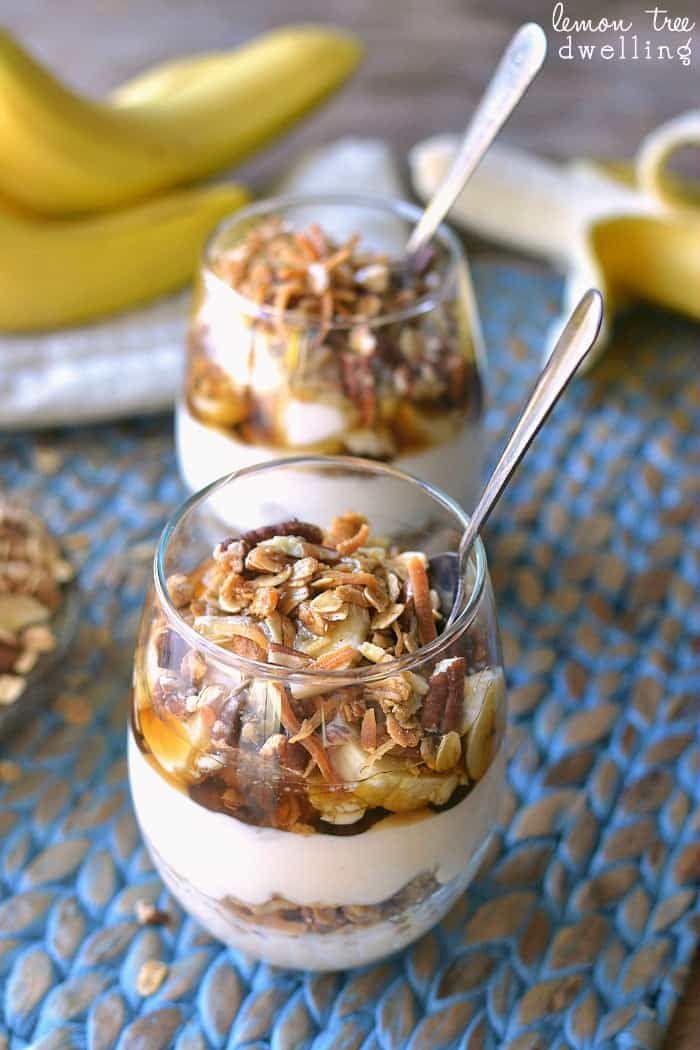 three desserts with bananas and nuts in them on a blue place mat next to other food items