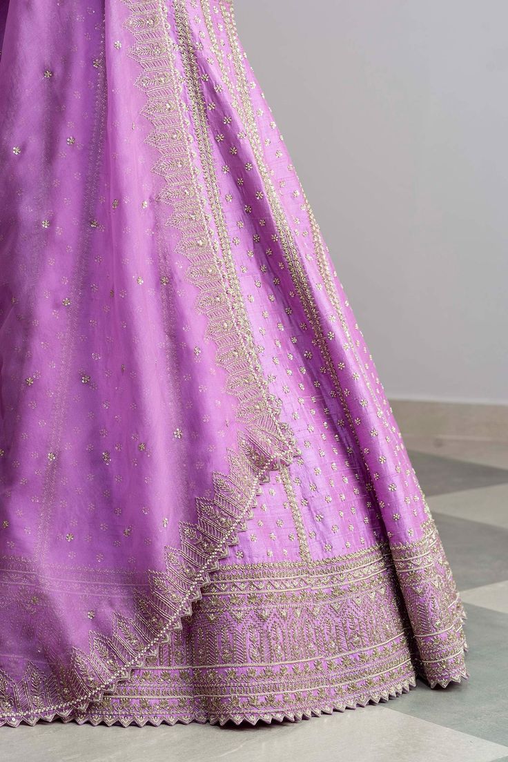 Lavender raw silk lehenga with cutdana worked temple border, striped pattern, floral motifs and cutwork hem. Comes with blouse and organza dupatta.
Components:3
Embroidered
Neckline:Square
Sleeve Length:Half
Fabric:Raw Silk; Dupatta: Organza
Color:Purple

Tie-up cutout back
Cutwork detail
Kamar tassels

 - Aza Fashions Raw Silk Lehenga, Anushree Reddy, Luxury Sale, Purple Tie, Silk Lehenga, Organza Dupatta, Embroidered Neckline, Silk Dupatta, Bridal Lehenga