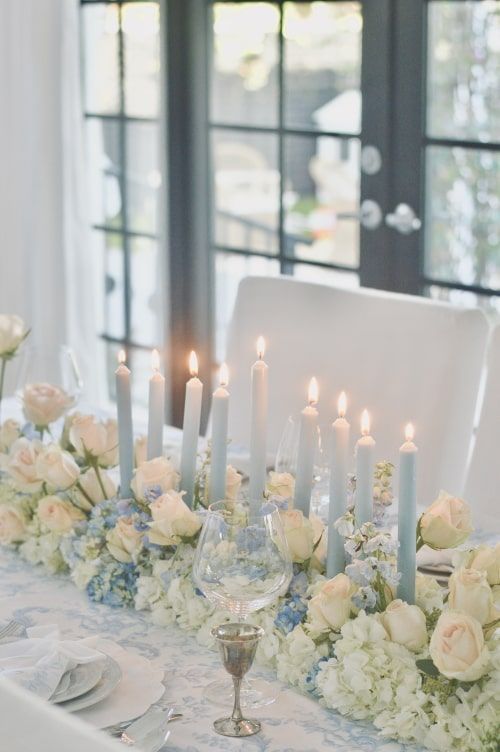 the table is set with white flowers and candles for an elegant wedding reception or special event