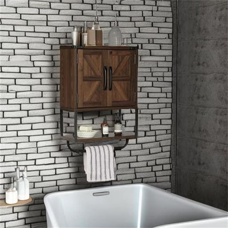 a white bath tub sitting under a wooden cabinet next to a brick wall in a bathroom