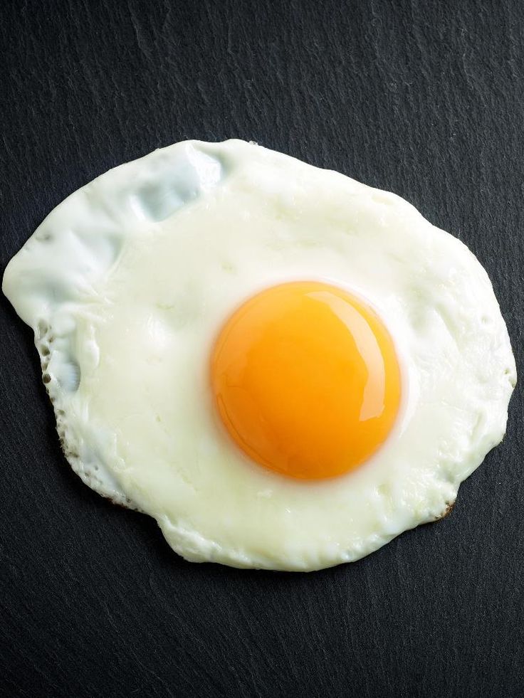 an egg is sitting on top of a black surface