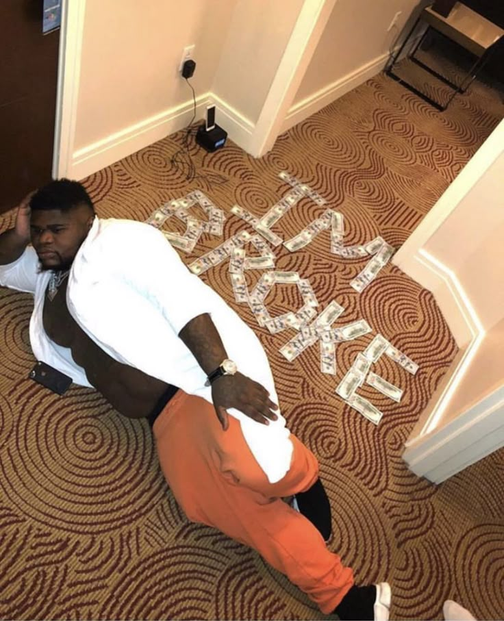 a man sitting on the floor in front of a sign