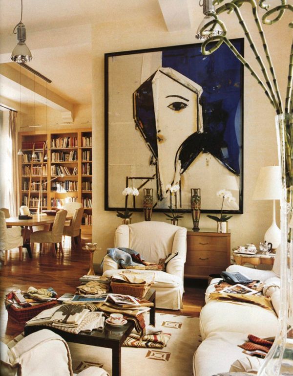 a living room filled with furniture and a painting on the wall