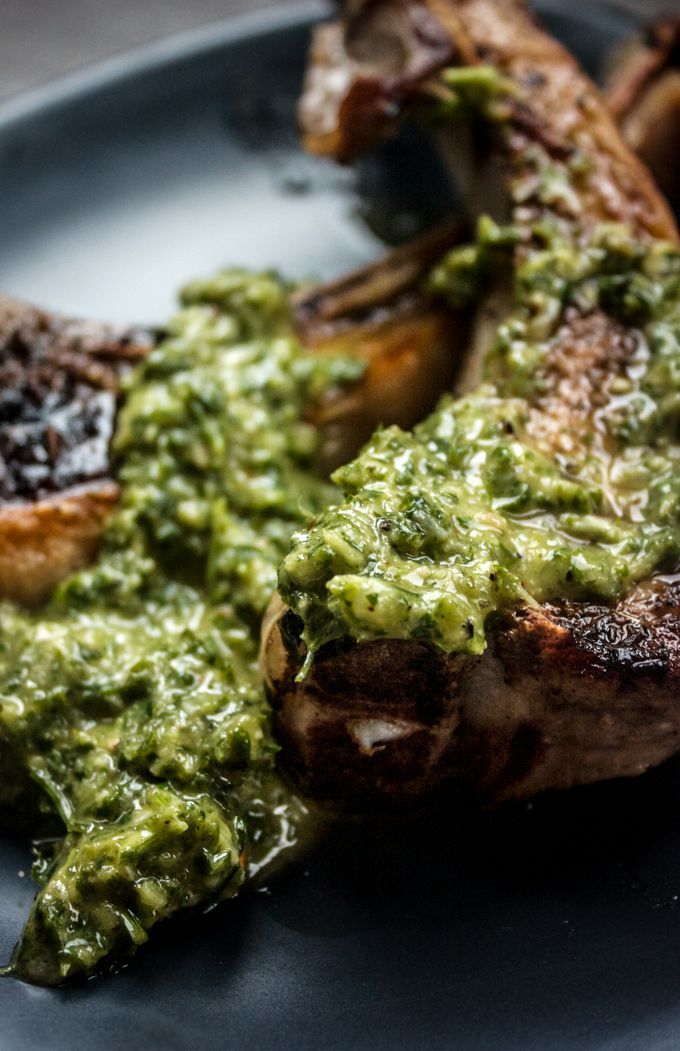 a plate topped with meat covered in green sauce