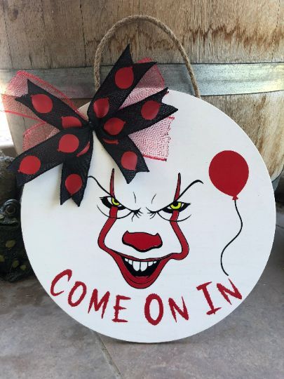 a sign that says, come on in with a clown face and balloon attached to it