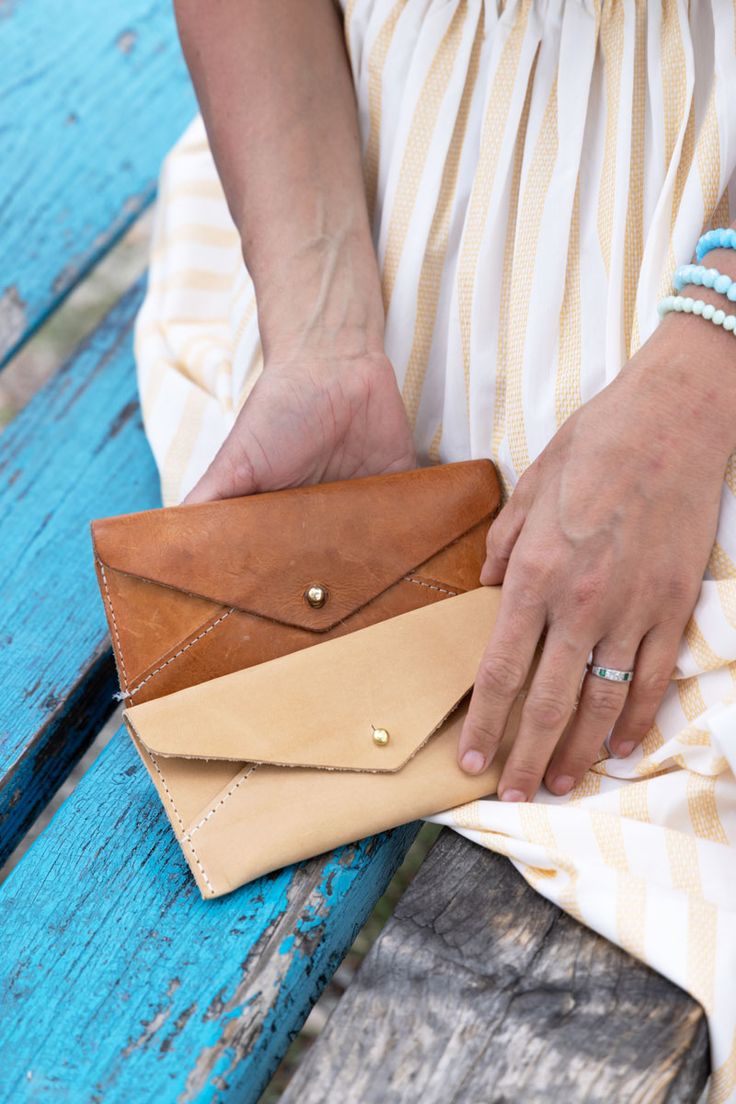 a woman sitting on a bench holding a wallet